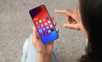 cell phone in hand with apps showing