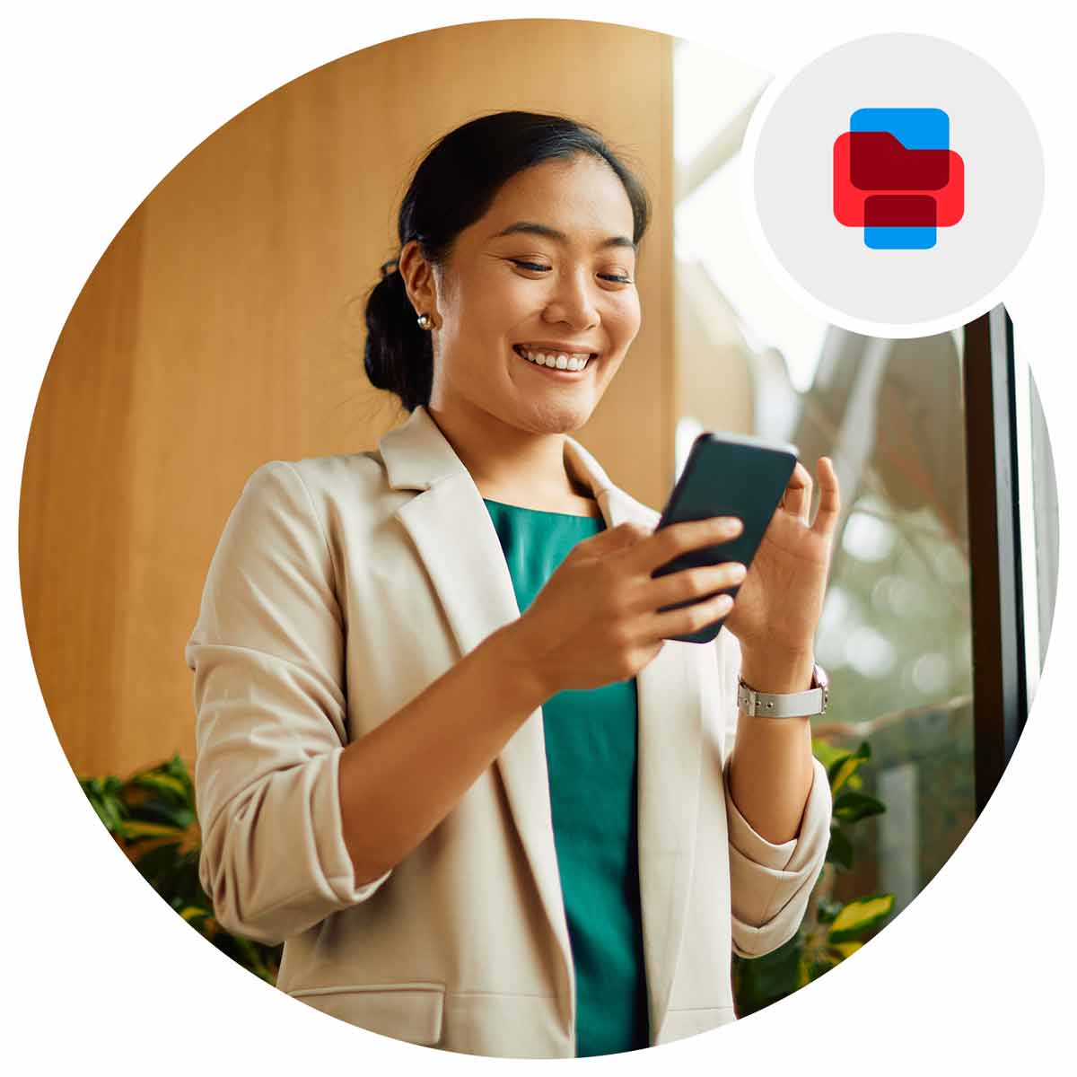 Woman is business attire holding her phone smiling