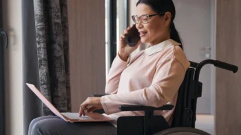 woman in wheelchair on laptop and phone