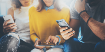 Group of people holding phones and a tablet