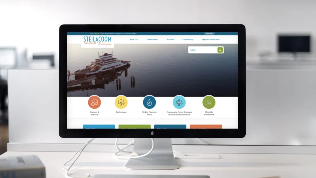 Steilacoom, WA website displayed on a Mac monitor in a white office setting