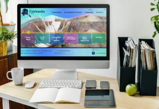 iMac computer on a desk with office stationery and books